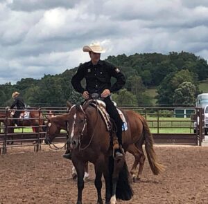 young man on brown horse in competition arena