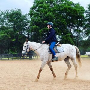 student on appaloosa horse in ring
