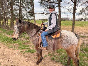 woman sitting on appaloosa's back